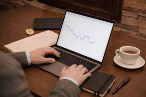 En person analyserar ett linjediagram på en bärbar dator.